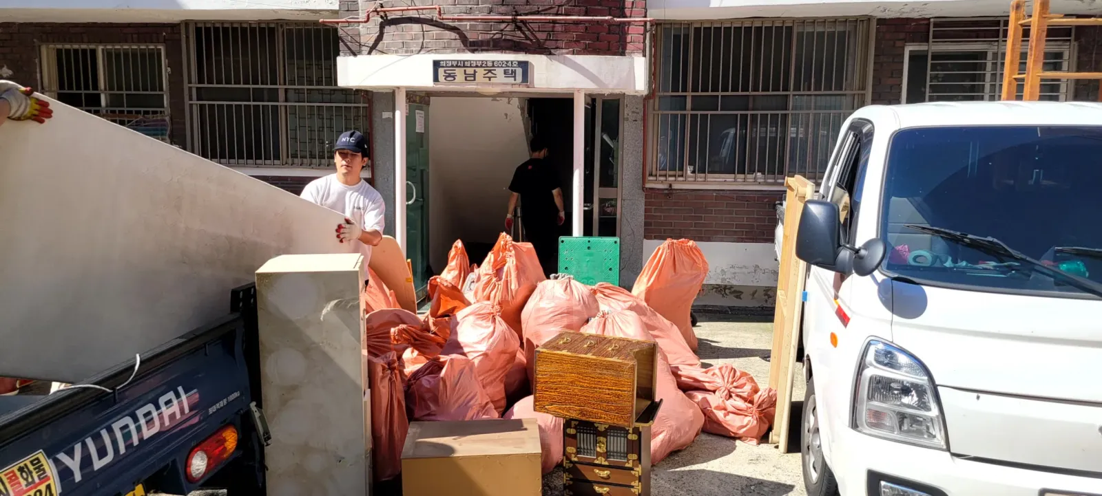상가 앞에서 폐기물을 트럭에 싣는 작업 현장